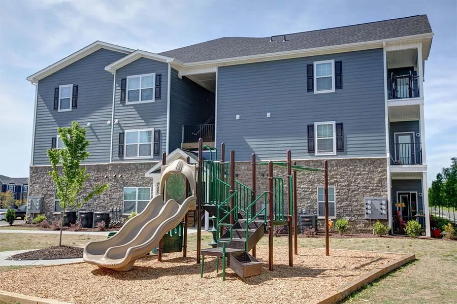 Apartment community playground and outdoor amenities area within a multifamily housing development